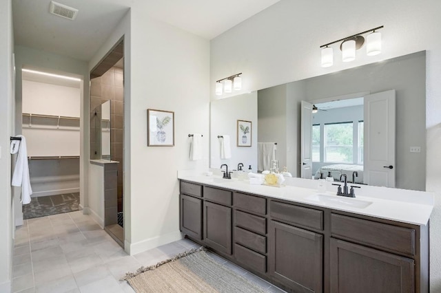 409 July Johnson Dr, Austin, TX 78737 - full bathroom featuring double vanity, a ceiling fan, a tile shower, tile patterned flooring, and a walk in closet