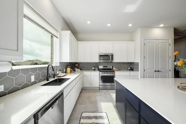 409 July Johnson Dr, Austin, TX 78737 - kitchen featuring appliances with stainless steel finishes, backsplash, light countertops, white cabinets, and light tile patterned floors