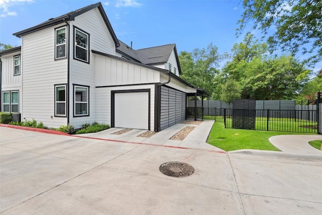 1125 Tillery St Unit 1A, Austin, TX 78702 - view of side of home with board and batten siding, an attached garage, and driveway
