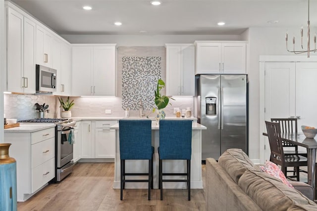 1125 Tillery St Unit 1A, Austin, TX 78702 - kitchen featuring stainless steel appliances, white cabinets, a kitchen island, light countertops, and recessed lighting