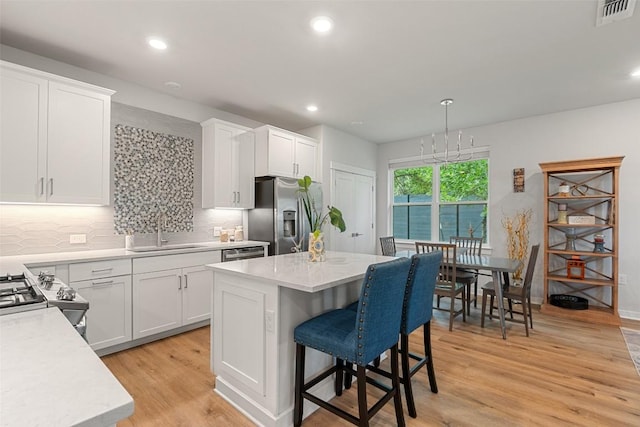 1125 Tillery St Unit 1A, Austin, TX 78702 - kitchen featuring stainless steel appliances, tasteful backsplash, white cabinets, light wood-type flooring, and recessed lighting