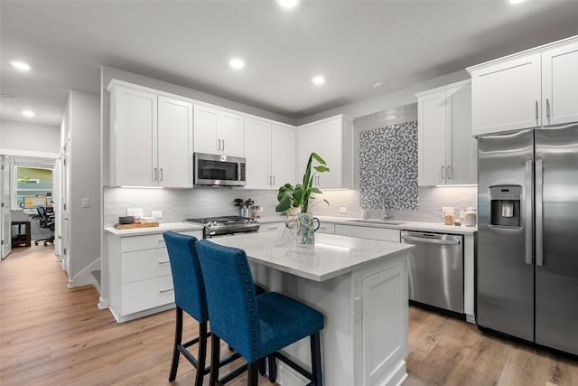 1125 Tillery St Unit 1A, Austin, TX 78702 - kitchen with appliances with stainless steel finishes, a kitchen island, white cabinetry, tasteful backsplash, and recessed lighting