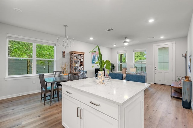 1125 Tillery St Unit 1A, Austin, TX 78702 - kitchen featuring light wood finished floors, a center island, light stone counters, white cabinetry, and recessed lighting