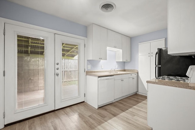 2021 Wheless Ln, Austin, TX 78723 - kitchen with dishwasher, light wood-style flooring, light countertops, french doors, and white cabinetry