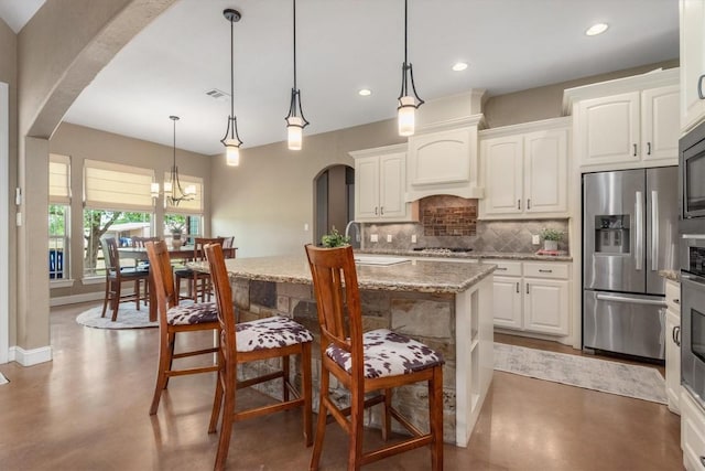 9769 Fm 1361, Snook, TX 77879 - kitchen featuring appliances with stainless steel finishes, arched walkways, finished concrete flooring, decorative backsplash, and recessed lighting