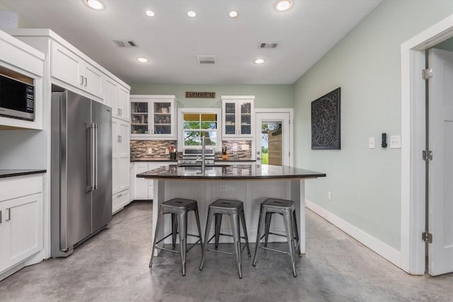 9769 Fm 1361, Snook, TX 77879 - kitchen with stainless steel appliances, concrete flooring, a kitchen bar, recessed lighting, and white cabinets