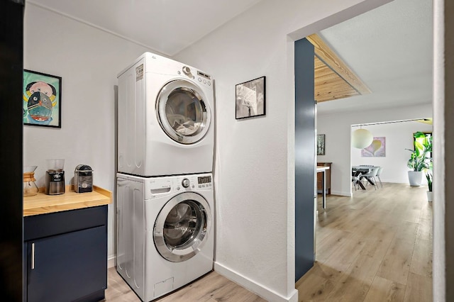 6101 Bridlington Cir, Austin, TX 78745 - washroom featuring stacked washing machine and dryer, light wood-type flooring, and cabinet space