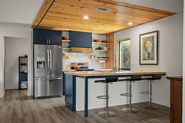 6101 Bridlington Cir, Austin, TX 78745 - kitchen featuring appliances with stainless steel finishes, open shelves, wood counters, blue cabinetry, and wood finished floors