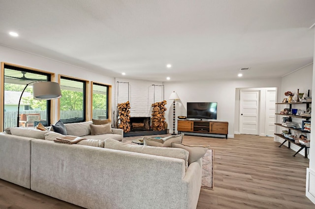 6101 Bridlington Cir, Austin, TX 78745 - living room featuring a fireplace with raised hearth, light wood-style floors, and recessed lighting