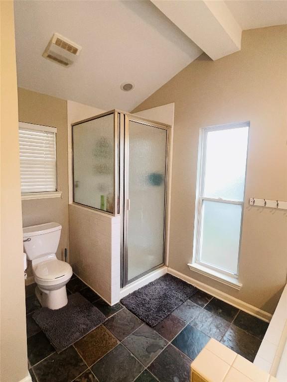 2003 Woodmont Ave, Austin, TX 78703 - bathroom with stone tile floors, plenty of natural light, a shower stall, and lofted ceiling