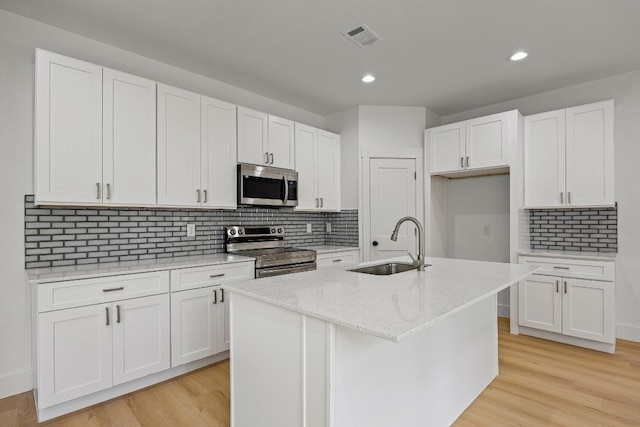 161 Honopu Dr, Bastrop, TX 78602 - kitchen featuring appliances with stainless steel finishes, white cabinets, decorative backsplash, recessed lighting, and light stone countertops