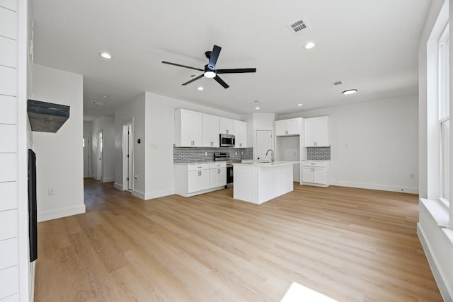 161 Honopu Dr, Bastrop, TX 78602 - kitchen with open floor plan, stainless steel appliances, ceiling fan, backsplash, and recessed lighting