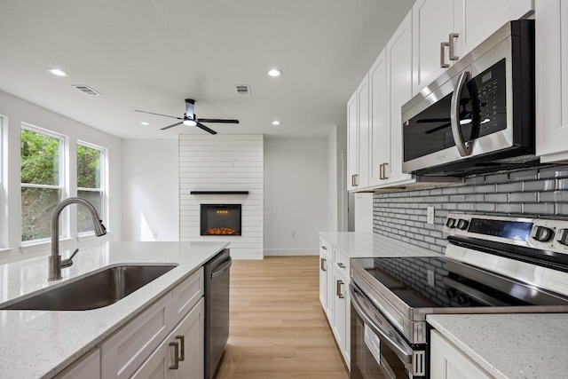 161 Honopu Dr, Bastrop, TX 78602 - kitchen with stainless steel appliances, decorative backsplash, ceiling fan, recessed lighting, and light wood finished floors