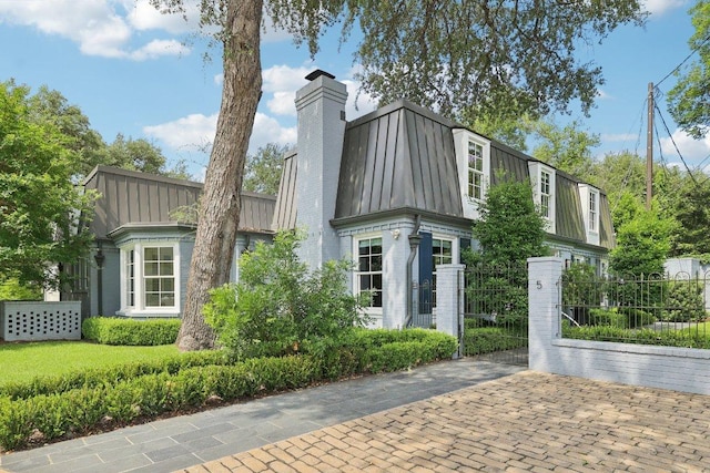 5 Green Ln, Austin, TX 78703 - view of front of home featuring a standing seam roof, a metal roof, a chimney, brick siding, and a gate