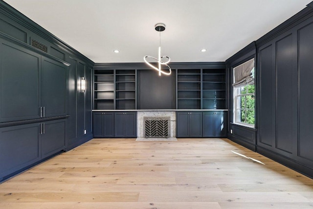 5 Green Ln, Austin, TX 78703 - unfurnished living room with light wood-type flooring, a chandelier, recessed lighting, built in features, and crown molding