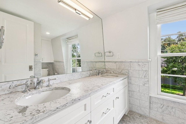 5 Green Ln, Austin, TX 78703 - bathroom with double vanity, tile walls, and a wainscoted wall