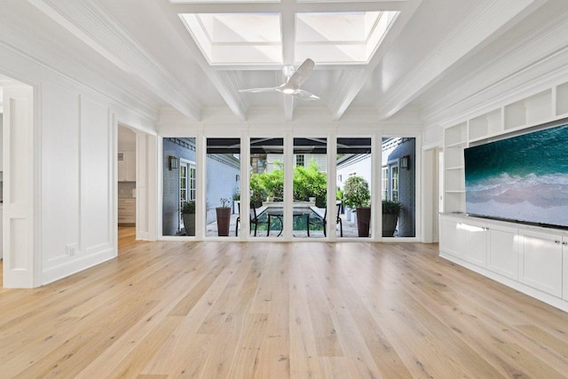 5 Green Ln, Austin, TX 78703 - spare room with beamed ceiling, ornamental molding, light wood-style floors, ceiling fan, and a skylight