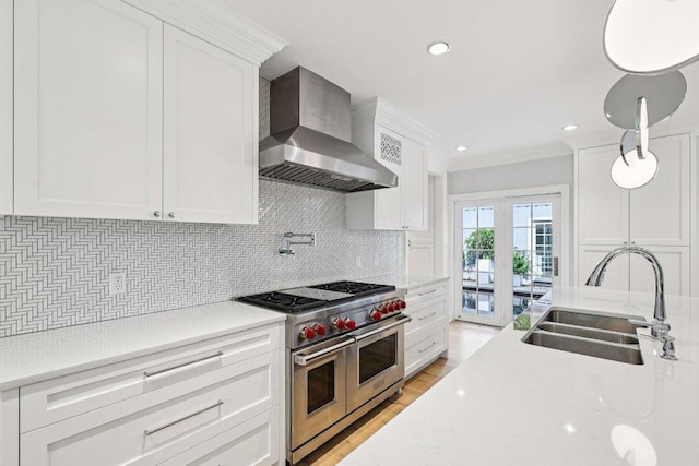 5 Green Ln, Austin, TX 78703 - kitchen featuring wall chimney range hood, range with two ovens, white cabinetry, tasteful backsplash, and recessed lighting