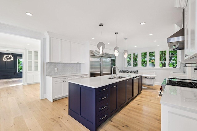 5 Green Ln, Austin, TX 78703 - kitchen featuring stainless steel appliances, a center island with sink, white cabinetry, light wood-type flooring, and recessed lighting