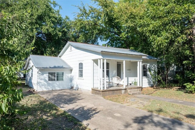 1028 E 43rd St, Austin, TX 78751 - view of front of property featuring a porch, driveway, and a metal roof