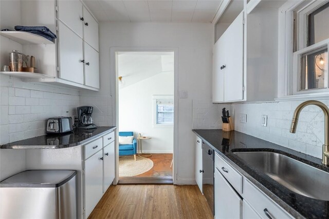 1028 E 43rd St, Austin, TX 78751 - kitchen featuring light wood-style flooring, white cabinets, tasteful backsplash, and open shelves