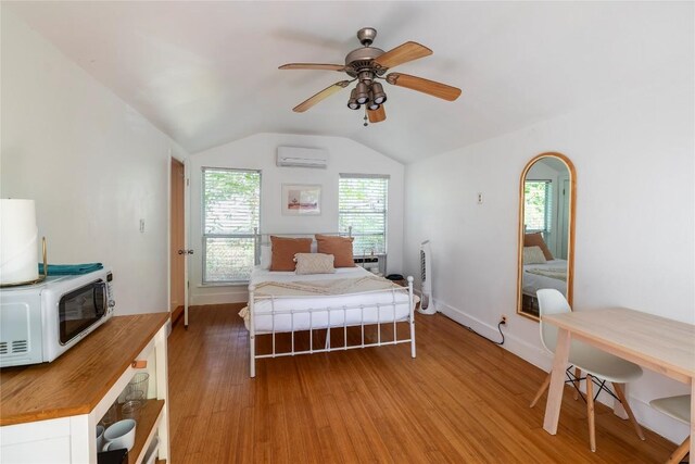 1028 E 43rd St, Austin, TX 78751 - bedroom featuring an AC wall unit, light wood-style floors, vaulted ceiling, and ceiling fan