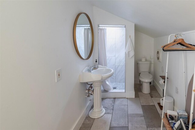 1028 E 43rd St, Austin, TX 78751 - full bathroom featuring a tile shower, vaulted ceiling, and tile patterned flooring