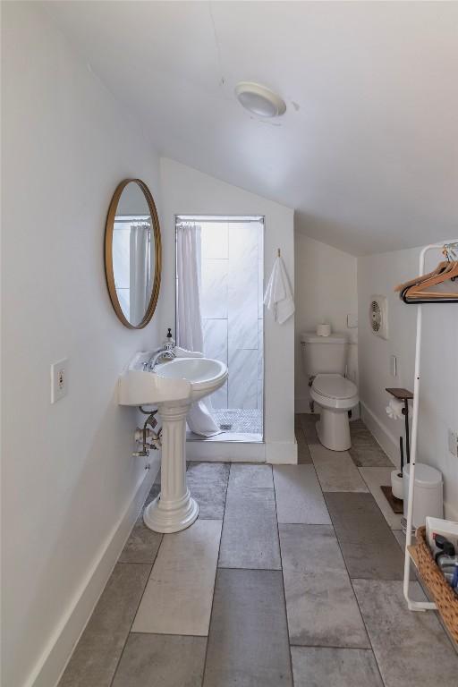 1028 E 43rd St, Austin, TX 78751 - bathroom with a stall shower, vaulted ceiling, and tile patterned flooring