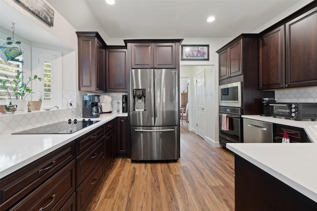 1004 Oaklands Dr, Round Rock, TX 78681 - kitchen with black appliances, light countertops, light wood-style flooring, decorative backsplash, and dark brown cabinets