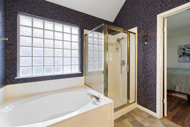 1004 Oaklands Dr, Round Rock, TX 78681 - bathroom with connected bathroom, a garden tub, a shower stall, wallpapered walls, and vaulted ceiling
