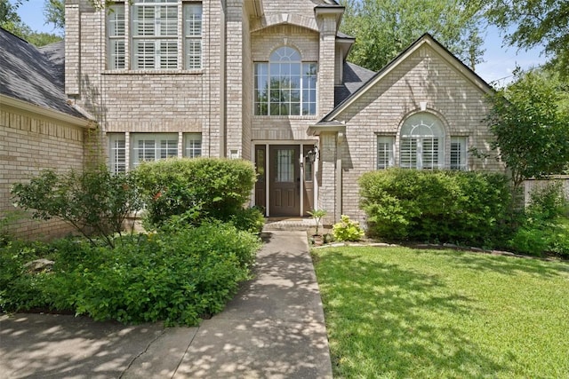 1004 Oaklands Dr, Round Rock, TX 78681 - view of exterior entry with a yard and brick siding
