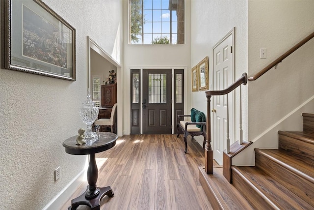 1004 Oaklands Dr, Round Rock, TX 78681 - foyer entrance with stairway, wood finished floors, a textured wall, and a towering ceiling