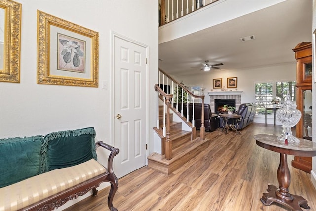 1004 Oaklands Dr, Round Rock, TX 78681 - entrance foyer featuring light wood-style flooring, stairs, ceiling fan, and a fireplace