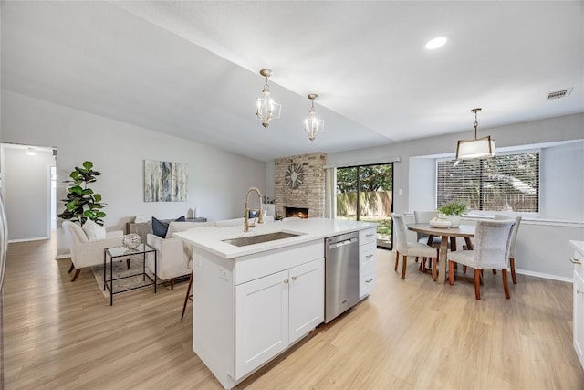 11309 Timbrook Trl, Austin, TX 78750 - kitchen featuring dishwasher, open floor plan, light wood-style floors, a large fireplace, and light countertops