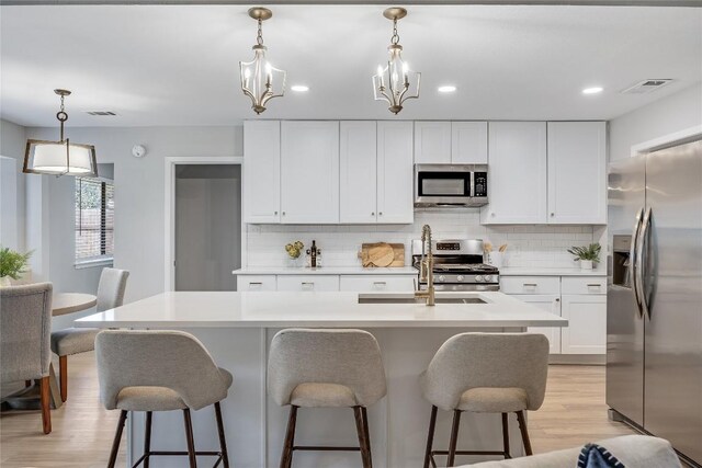 11309 Timbrook Trl, Austin, TX 78750 - kitchen with stainless steel appliances, tasteful backsplash, light wood-style flooring, white cabinetry, and recessed lighting