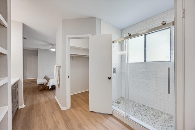 11309 Timbrook Trl, Austin, TX 78750 - full bathroom featuring a stall shower, wood finished floors, vanity, and a walk in closet