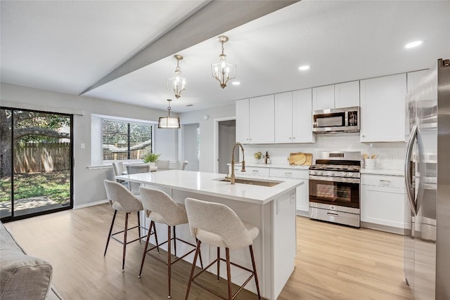 11309 Timbrook Trl, Austin, TX 78750 - kitchen with stainless steel appliances, light wood-style flooring, a chandelier, light countertops, and decorative backsplash