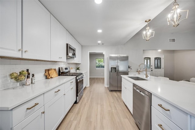 11309 Timbrook Trl, Austin, TX 78750 - kitchen with appliances with stainless steel finishes, a chandelier, backsplash, white cabinets, and recessed lighting