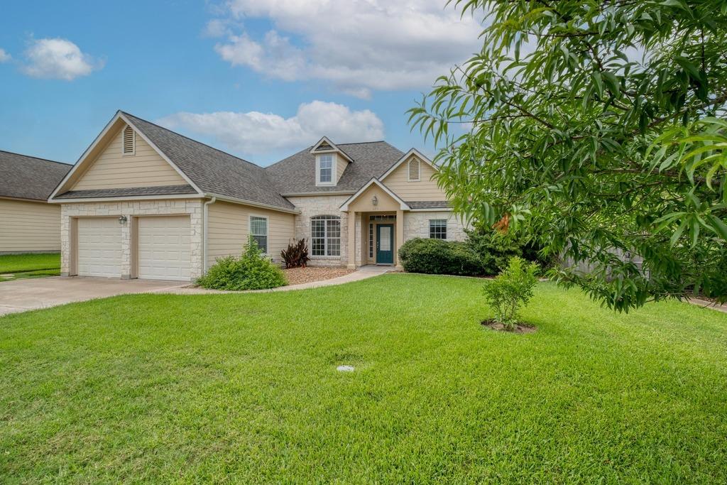 365 Rose Mayer Loop, La Grange, TX 78945 - traditional-style house with concrete driveway, a garage, stone siding, a front lawn, and roof with shingles