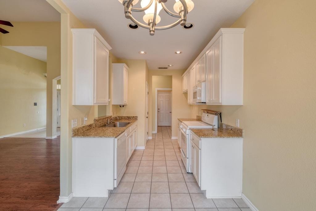 365 Rose Mayer Loop, La Grange, TX 78945 - kitchen with white appliances, white cabinets, a chandelier, light stone counters, and recessed lighting