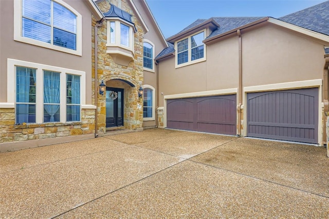 217 Emerald Ridge Dr, Austin, TX 78732 - view of front of property with stone siding, stucco siding, driveway, and roof with shingles