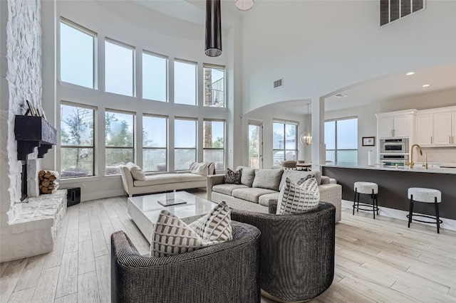 217 Emerald Ridge Dr, Austin, TX 78732 - living room with a high ceiling, plenty of natural light, arched walkways, and light wood-style floors