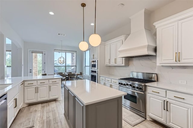 217 Emerald Ridge Dr, Austin, TX 78732 - kitchen featuring appliances with stainless steel finishes, premium range hood, white cabinets, and recessed lighting