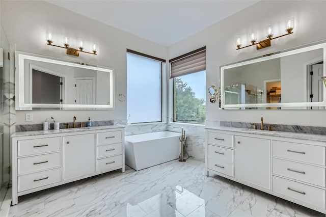 217 Emerald Ridge Dr, Austin, TX 78732 - full bathroom featuring two vanities, a freestanding bath, and marble finish floors
