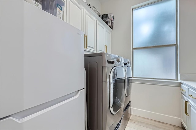 217 Emerald Ridge Dr, Austin, TX 78732 - laundry area with washer and clothes dryer, cabinet space, and light wood-style floors
