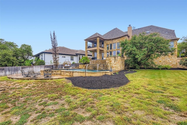217 Emerald Ridge Dr, Austin, TX 78732 - back of house with stone siding, a balcony, a chimney, and a patio area