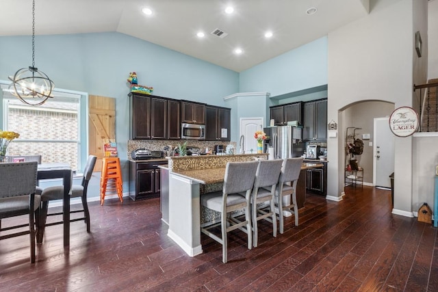 137 Paul Azinger Dr, Round Rock, TX 78664 - kitchen with stainless steel appliances, high vaulted ceiling, a chandelier, a kitchen island with sink, and a breakfast bar area