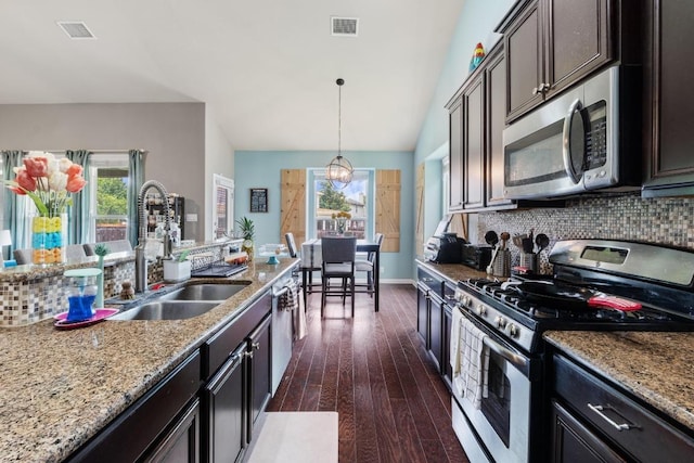 137 Paul Azinger Dr, Round Rock, TX 78664 - kitchen featuring appliances with stainless steel finishes, plenty of natural light, decorative backsplash, dark wood-style flooring, and vaulted ceiling