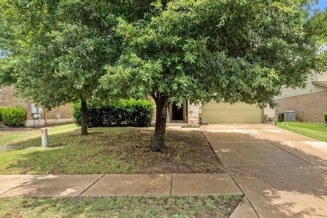 137 Paul Azinger Dr, Round Rock, TX 78664 - view of property hidden behind natural elements featuring concrete driveway, an attached garage, a front lawn, and stone siding