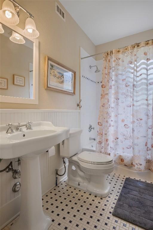 903 E 14th St, Austin, TX 78702 - full bathroom with tile patterned floors, shower / bath combination with curtain, and wainscoting